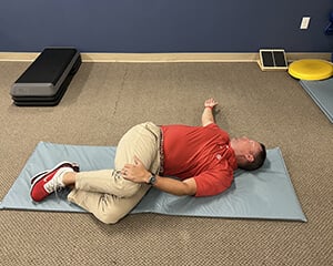 man laying on his side stretching his torso